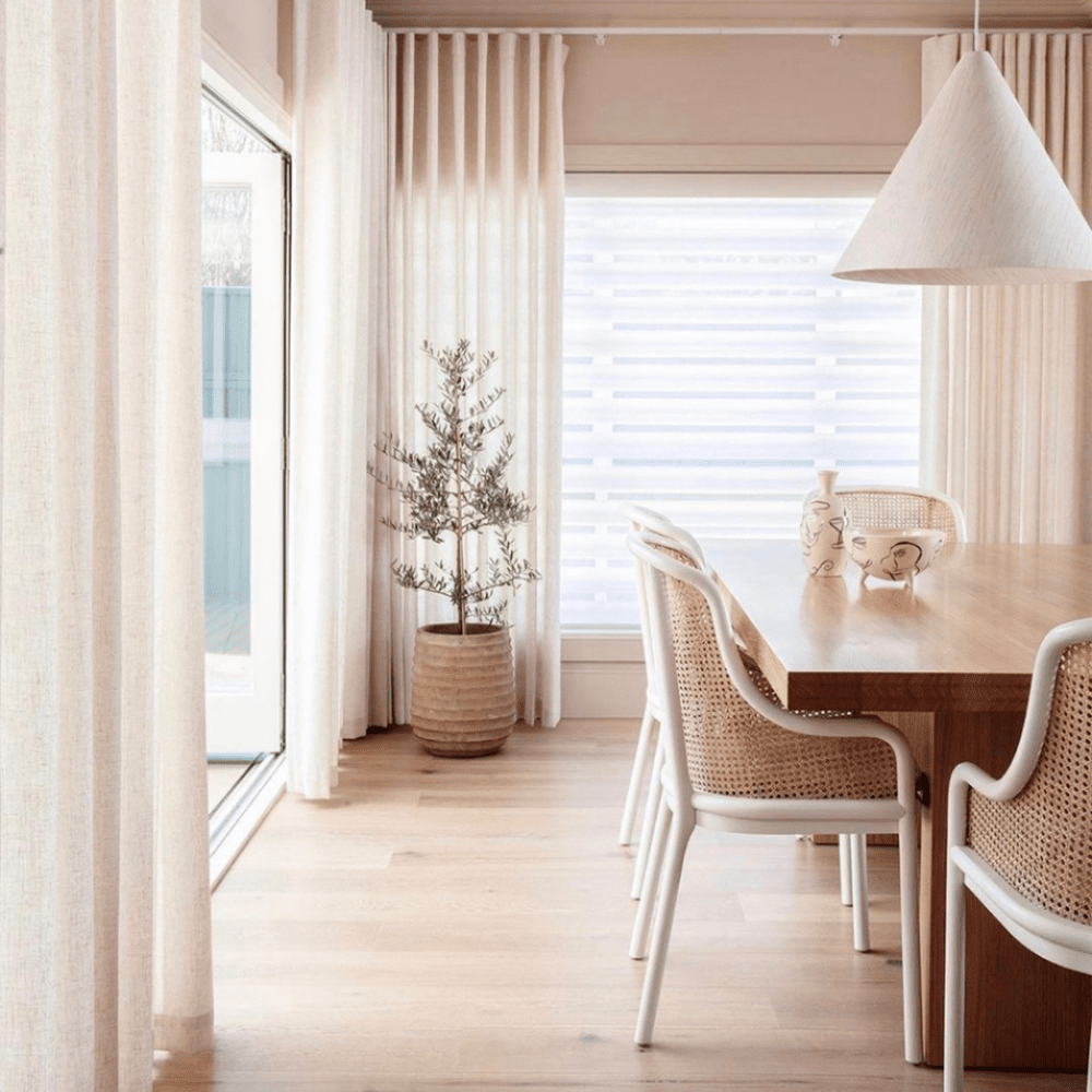 Linen drapery and cane dining chairs in morning light.