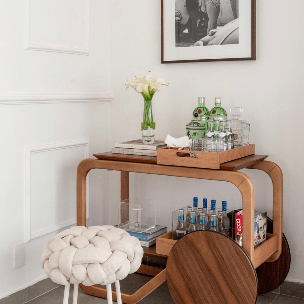 A bentwood bar cart styled in the corner.