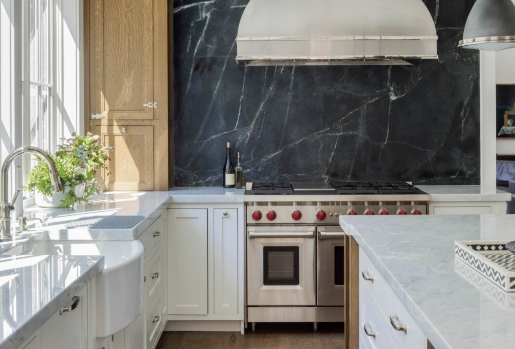 Sunlit kitchen with soapstone backsplash, marble counters and white oak cabinetry